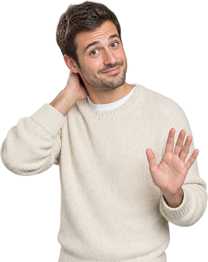 Un homme au sourire gêné, une main sur la nuque, l’autre levée paume ouverte