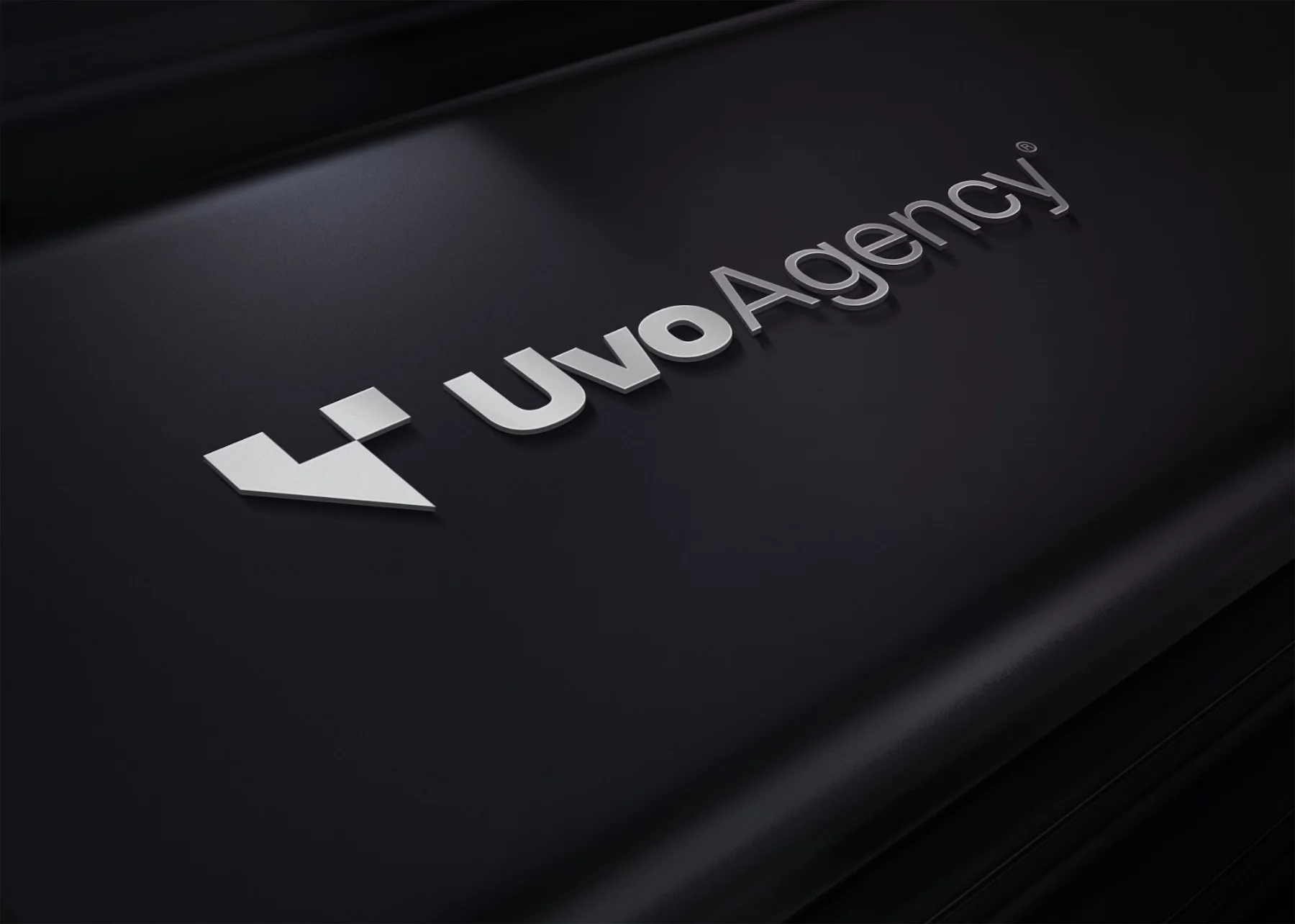 Le logo Uvo Agency en relief sur du métal
